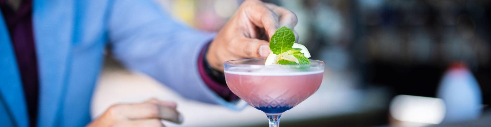 Signature cocktail at Auckland airport restaurant with mint and citrus garnish